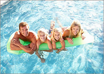 Family on a pool float in a custom pool built by Dreamscapes by MGR Southern California's leading custom swimming pool and landscape contractor and design firm.