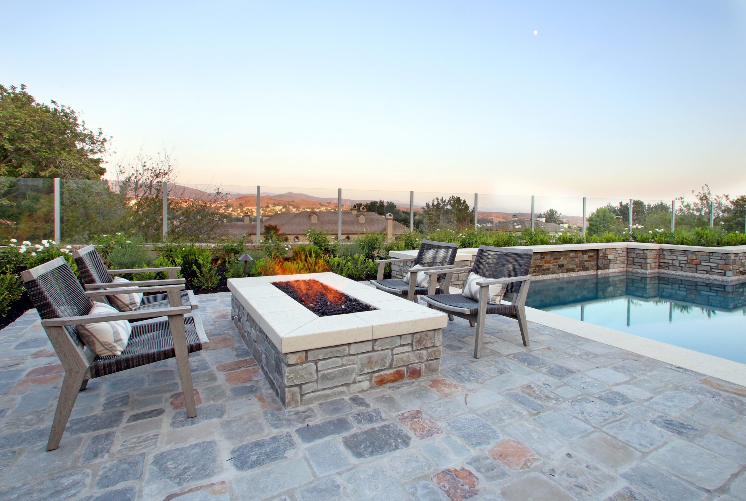 Natural stone deck and raised firepit, concrete cap and coping, Dreamscape by MGR leading pool contractor in Orange County
