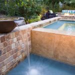 Pot basin waterfall into pool - travertine veneer, natural stone, raised spa and firepit, Dreamscape by MGR leading pool contractor in Orange County