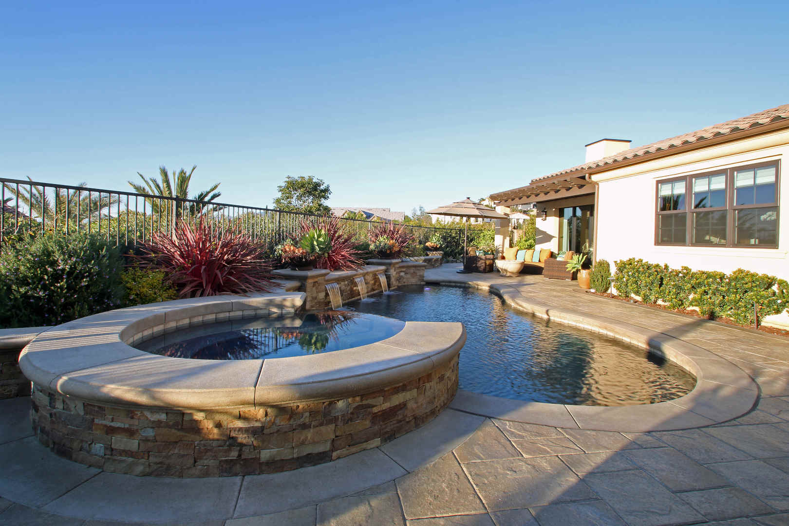 Elegant freeform pool and spa with stone hardscape, Dreamscape by MGR leading pool contractor in Orange County